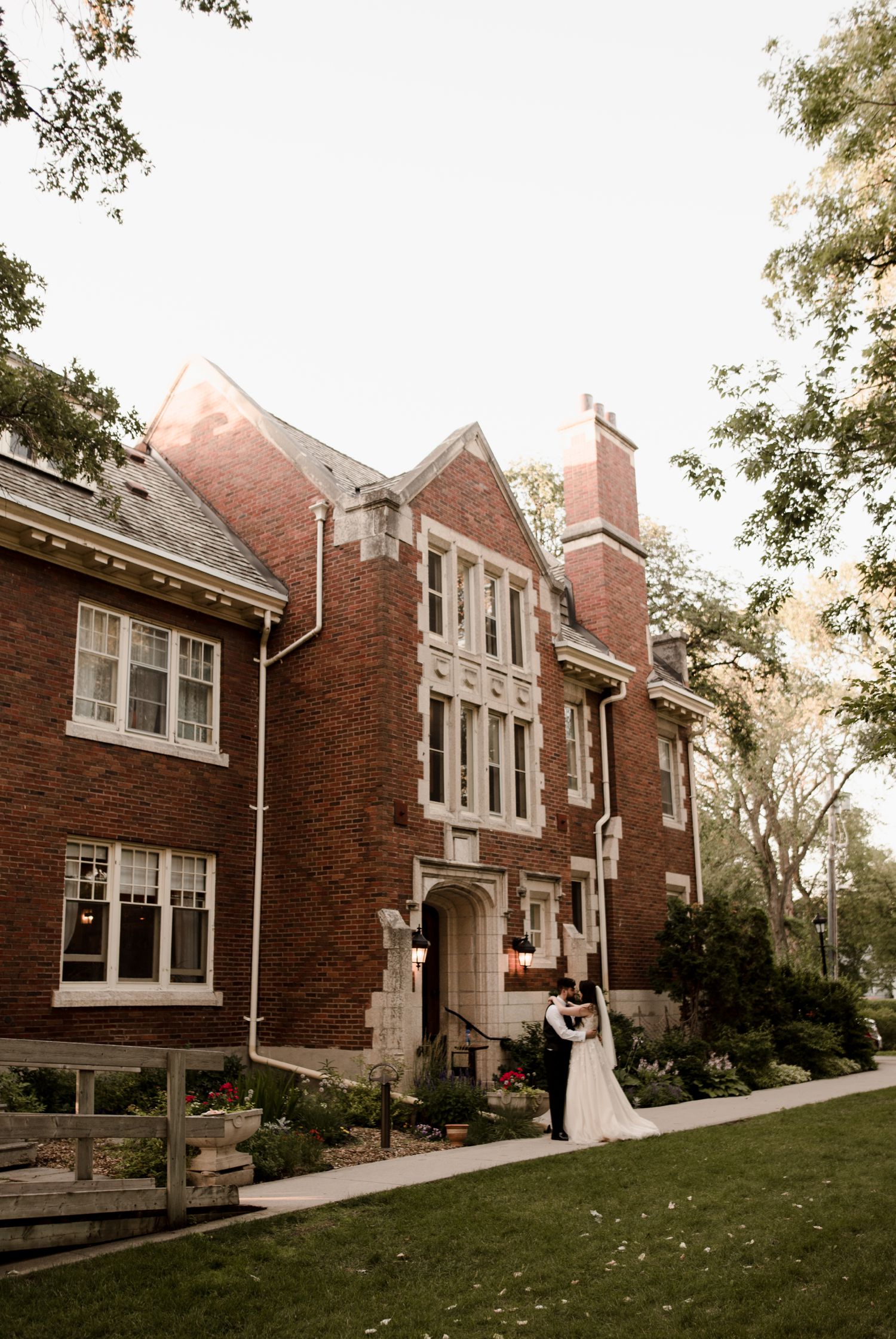 wedding couple at their downtown winnipeg wedding standing outside the Ralph Connor house in the summer. Photos by Vanessa Renae Photography