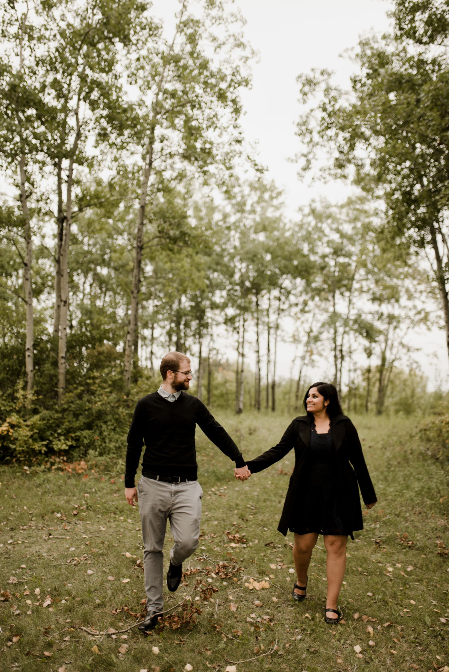 engaged couple walking hand in hand at Birds hill park for their fall engagement session. Photographed by Vanessa Renae Photography, a Canadian engagement photographer, always available for travel.