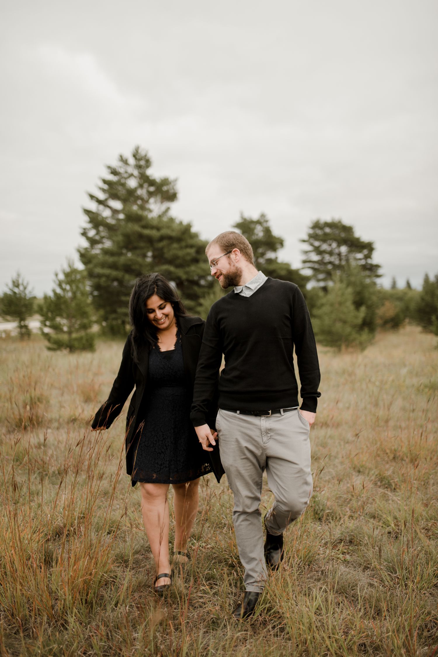 engaged couple walking hand in hand at Birds hill park for their fall engagement session. Photographed by Vanessa Renae Photography, a Canadian engagement photographer, always available for travel.