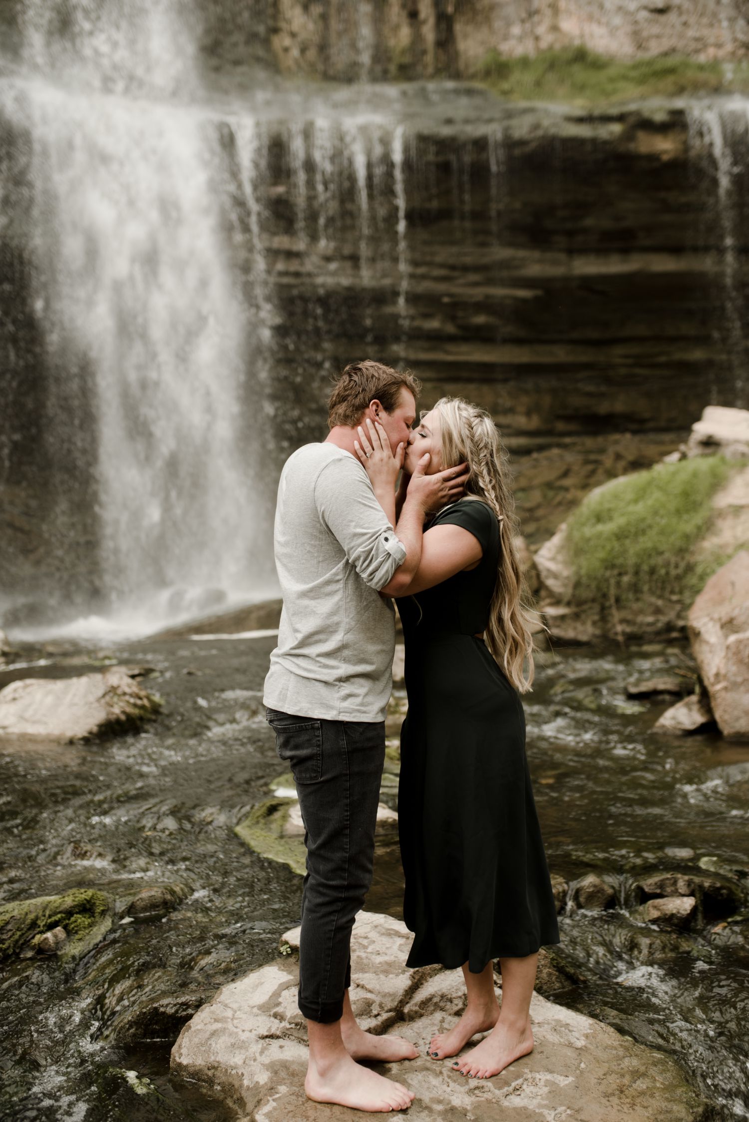 Hamilton waterfall engagement, Ontario wedding photographer, Canadian elopement photographer, Vanessa Renae Photography, couple standing on a rock, kissing in front of a waterfall in Dundas Valley, Hamilton Ontario.